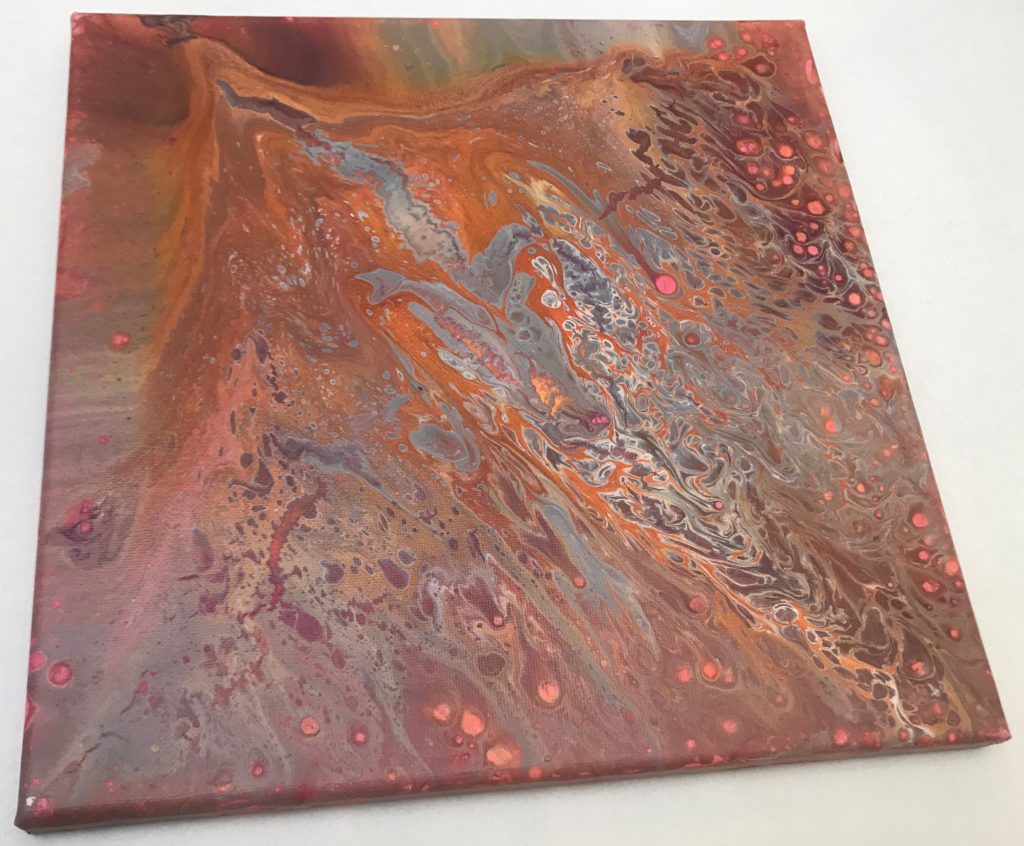 This image shows a canvas that has pours, swirls, and dots of paint in colors of rusts, pinks, oranges, whites, greys, and silvers.