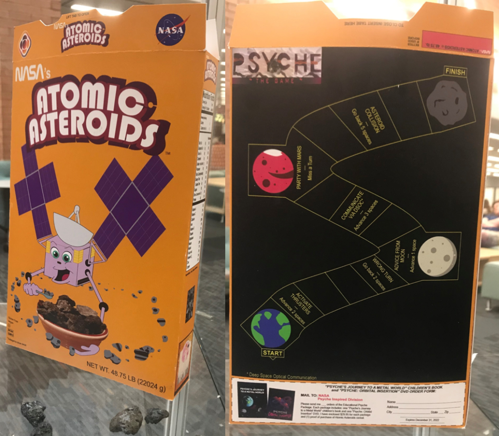 This image shows the front, side, and back of a custom cereal box for "Atomic Asteroids" cereal. On the front is the Psyche spacecraft eating asteroids from a bowl. On the back is a space board game and a coupon for ordering the Psyche coloring book.