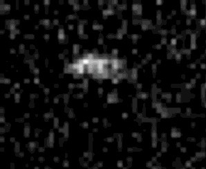 This shows a very pixelated grey blob (the Psyche asteroid) on a black background.