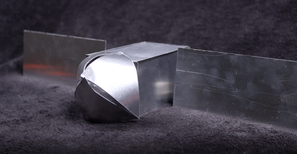 a small model of the psyche spacecraft made of thin metal.