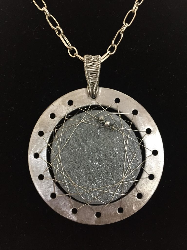 Pendant made from a glittering, rough-cut piece of specular hematite that is suspended by an orbit of fine stainless steel wire with a miniature version of the Psyche probe.