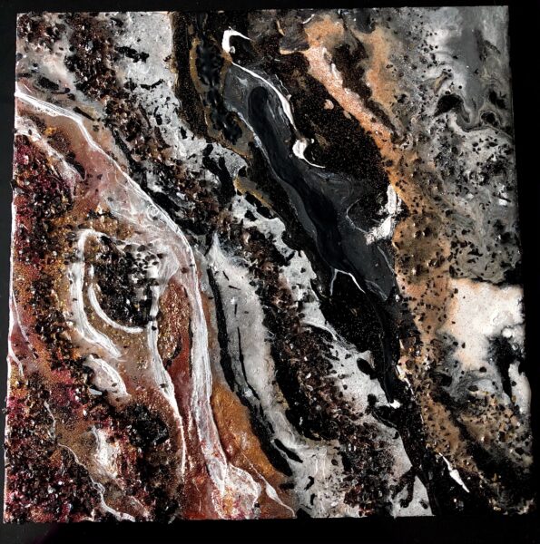 This abstract piece has gold, orange, and red streaks of paint on the bottom left corner with black crystals sprinkled over it. The paint is blended with black and white streaks. The black crystal textures and gold and silver glitter are present in most of the piece. The overall piece has a marble-like finish and appearance.