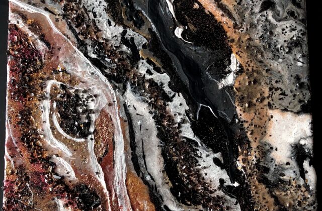This abstract piece has gold, orange, and red streaks of paint on the bottom left corner with black crystals sprinkled over it. The paint is blended with black and white streaks. The black crystal textures and gold and silver glitter are present in most of the piece. The overall piece has a marble-like finish and appearance.