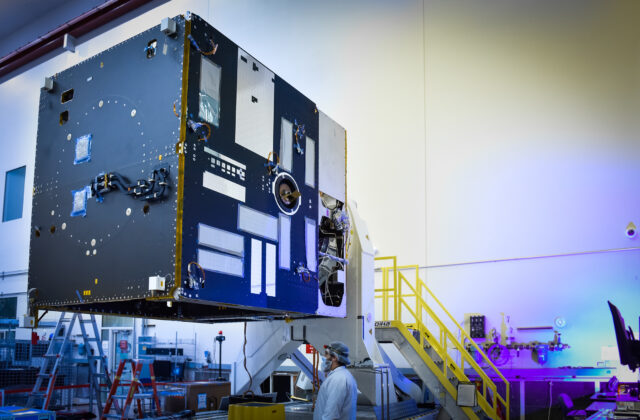 This image is of the black and silver main body of the Psyche Spacecraft. The equipment panels have been mated to Psyche’s propulsion module and technicians will soon begin installing attitude control components.