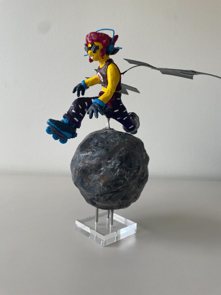 A clay sculpture of a skater girl, reimagining NASA’s Psyche spacecraft. She soars mid-air over the 16 Psyche asteroid, her rollerblades powered by hall thrusters. Sunglasses mimic solar cells, and sleek wings extend from her back. Painted in Psyche mission colors, the piece blends science and art, capturing the excitement of space exploration.